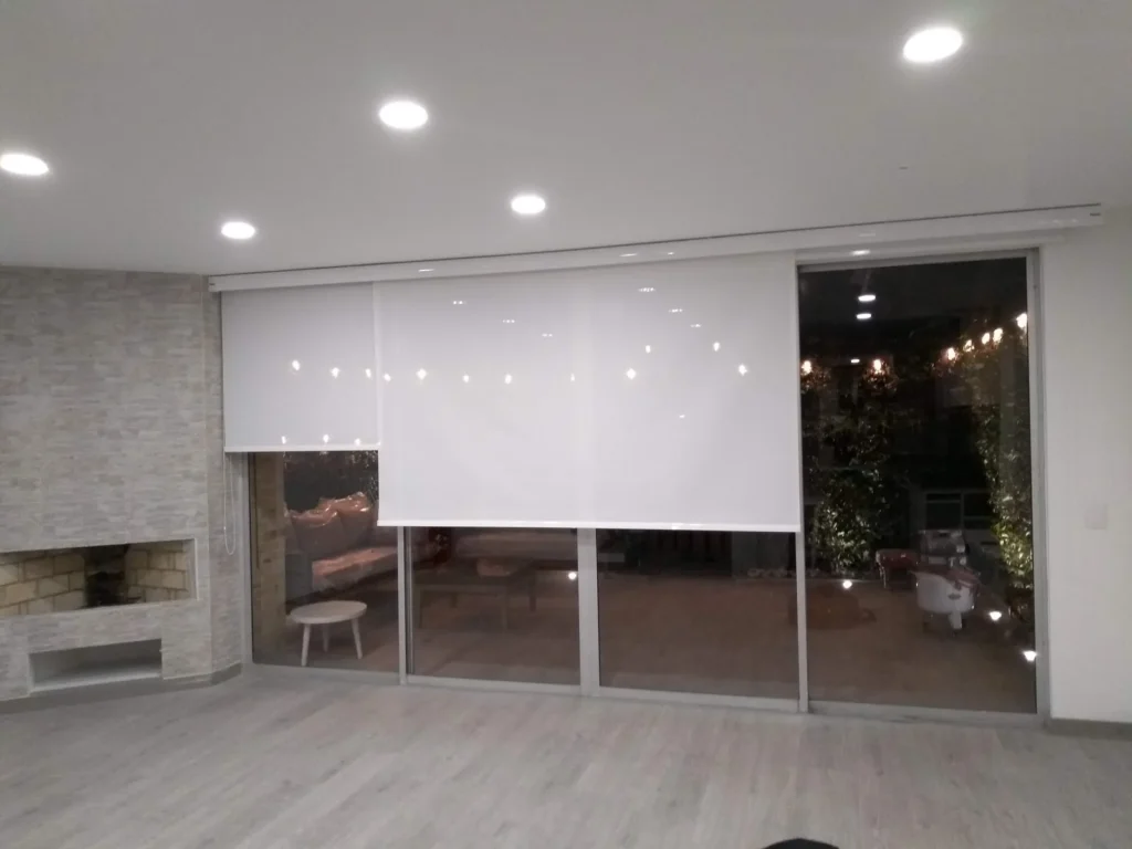 Cortinas enrollables screen blancas en el ventanal de una sala con piso laminado gris