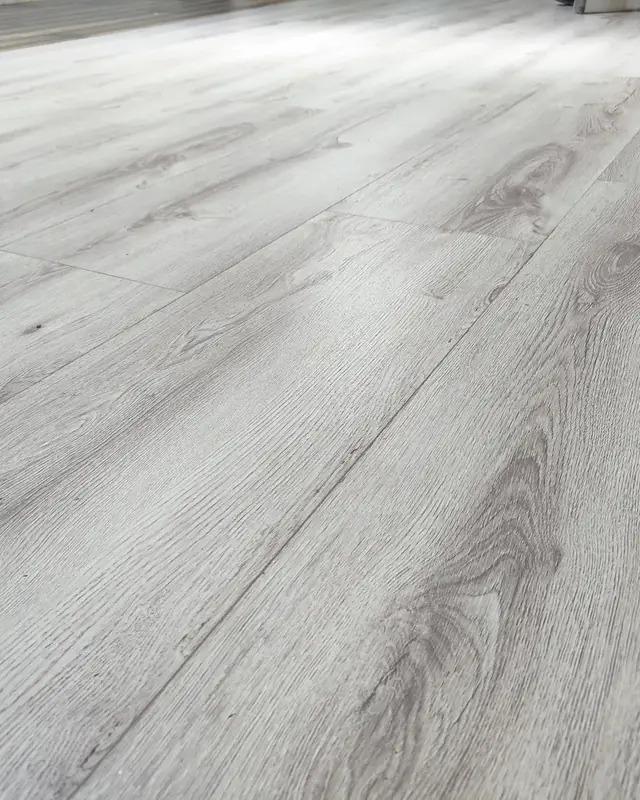 Piso gris tipo madera instalado en un espacio amplio